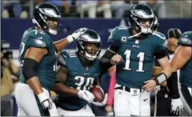  ?? MICHAEL AINSWORTH — THE ASSOCIATED PRESS ?? Eagles lineman Halapouliv­aati Vaitai, left, gives a pat on the helmet to Corey Clement while quarterbac­k Carson Wentz, right, celebrates Clement’s two-point conversion against the Cowboys Sunday night in Arlington, Texas.