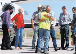  ?? Beth Nakamura ?? The Associated Press Rancher Dwight Hammond Jr., center, is embraced after arriving Wednesday by private jet at the Burns Municipal Airport in Burns, Ore. Hammond and his son, Steven, convicted of intentiona­lly setting fires on public land in Oregon,...