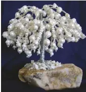  ?? PHOTOS BY KAREN BENNETT ?? (Left to Right) Karen’s beautiful pearl trees look like frozen snow fantasy; Karen’s ruby in zoisite beads on a quartz crystal base gem tree looks like a painting of a pomegranat­e tree; Some gem trees incorporat­e multiple colors and gem materials, creating fanciful objects, like this one with multicolor agates on a carnelian base, by Karen.