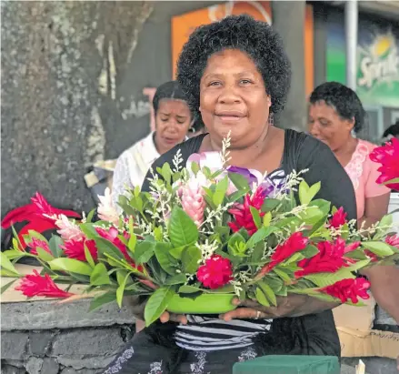  ?? Photo: Sheldon Chanel ?? Mereseini Tabuakases­e shows a sample of floral art that is part of her business.