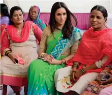  ??  ?? Mercy mission: Meghan in a sari talks to local women and also helps a group of children with planting flowers