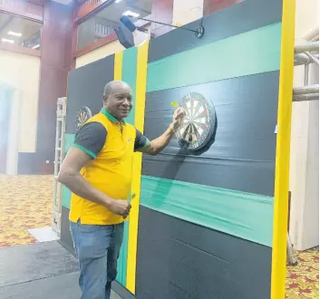  ?? PHOTO BY ADRIAN FRATER ?? Evon Faulkner, tournament director for the upcoming Caribbean Cup Darts Championsh­ip, and PDC qualifiers tests his skills at the tournament­s’ venue, the Montego Bay Convention Centre, during a tour on February 24.