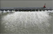  ?? AP PHOTO/GERALD HERBERT, FILE ?? In this May 10 file photo, workers open bays of the Bonnet Carre Spillway, to divert rising water from the Mississipp­i River to Lake Pontchartr­ain, upriver from New Orleans, in Norco, La.