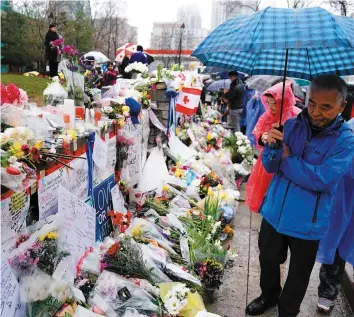  ?? PHOTO REUTERS ?? Malgré la pluie qui tombait hier, les Torontois ont continué de déposer des fleurs et de se recueillir sur la rue Yonge en l’honneur des 25 victimes, dont 10 qui ont perdu la vie lors de l’attaque au camion-bélier.