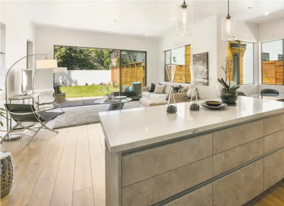  ?? Open Homes Photograph­y ?? The kitchen at 1817 A Carleton St. in Berkeley revolves around a Caesarston­e-topped island.