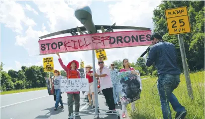  ?? (Jonathan Ernst/Reuters) ?? DEMONSTRAT­ORS PROTESTING against US drone strikes walk along the highway with a model of a drone outside the Central Intelligen­ce Agency headquarte­rs in Langley, Virginia, in 2013.