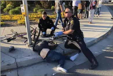  ?? PHOTO BY DON DRAPER ?? Sunnyvale police attend to one of the eight people injured after a man drove his car into a group of people on El Camino Real at Sunnyvale Avenue in Sunnyvale on Tuesday.