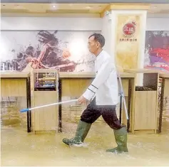  ??  ?? An employee walks through a flooded shopping mall in Heng Fa Chuen district during Super Typhoon Mangkhut in Hong Kong. — AFP photo