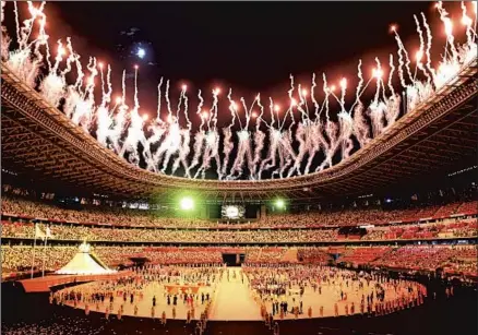  ?? Wally Skalij Los Angeles Times ?? FIREWORKS light the sky above Olympic Stadium in Tokyo, part of a sometimes somber opening ceremony to start the Games.