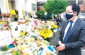  ?? AP FILE PHOTO/SUDHIN THANAWALA ?? New Jersey Rep. Andy Kim looks over flowers and messages at a memorial for the victims of the March 16 shootings in front of Gold Spa in Atlanta.