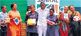  ?? ?? Moses Mthembu (centre) with teachers and pupils proudly showing their donated items