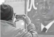  ?? BRYAN TERRY/THE OKLAHOMAN ?? Lloyd Davis takes a photo of a new mural that honors his cousin Capt. Riley Leroy Pitts during an unveiling at Pitts Park in Oklahoma City on Nov. 11.