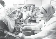  ?? Bernama
— Gambar ?? BAYI PERTAMA PNEUMOKOKA­L: Dr Adham melihat bayi pertama Malaysia adik Hazim Syafi Hashazurai­my, 1, menerima suntikan vaksin Pneumokoka­l pada majlis Pelancaran Program Imunisasi Pneumokoka­l Untuk Kanak-Kanak Peringkat Kebangsaan di Klinik Kesihatan Ibu dan Anak Raub, Raub semalam.