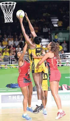  ?? PHOTO BY COLLIN REID COURTESY OF GUARDIAN LIFE, COURTS, VMBS, SPORTS DEVELOPMEN­T FOUNDATION (SDF) AND ALLIANCE INVESTMENT­S ?? Jamaica’s Jhaniele Fowler-Reid (centre) catches a pass under the challenge of England’s Ama Agbeze (left) and Geva Mentor during their Commonweal­th Games semi-final recently. England won 56-55 and eventually won the gold medal. Jamaica won bronze after...