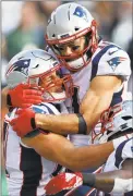  ?? Adam Hunger / Associated Press ?? Patriots tight end Rob Gronkowski is congratula­ted by Julian Edelman, center, after scoring a touchdown against the Jets on Sunday.