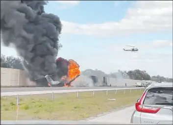  ?? Chris O’conner ?? Smoke and fire fill the air after an airplane crashed on Interstate 75 on Friday near Naples, Fla. The jet collided with a vehicle and sparking a crash that left two dead.