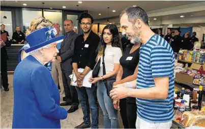  ??  ?? ROYAL VISITOR: The Queen meets resident and volunteer organiser Rashid Iqbal at a shelter for fire victims