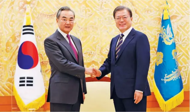 ?? Associated Press ?? ↑
Moon Jae-in (right) greets Wang Yi before a meeting at the presidenti­al Blue House in Seoul on Thursday.