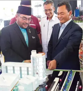  ?? — JOSEPH WONG/The Star ?? Mohd Salem (right) explaining the Wakaf Seetee Aisah 2 project to Mujahid (left) as Penang Islamic Religious Affairs Department director Zulkifli Long (centre) looks on.