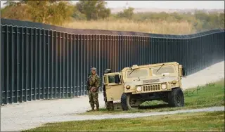  ?? Eric Gay / Associated Press file photo ?? National Guardsmen stand watch over a fence near the Internatio­nal bridge where thousands of Haitian migrants had created a makeshift camp on Sept. 18, 2021, in Del Rio, Texas.