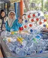  ?? — AFP ?? This picture taken on July 21, 2019 shows commuters exchanging plastic bottles for Suroboyo bus tickets at a terminal in the Indonesian city of Surabaya.