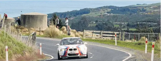  ?? PHOTO: JOHN FRIDD ?? Out for a drive . . . Australian­s Adam Kaplan and Alesia Penney take a corner on Saddle Hill Rd, above Brighton, in their BMW M3 CSL during the Targa Rally yesterday.