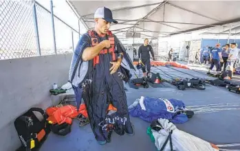  ?? EDUARDO CONTRERAS U-T PHOTOS ?? Sky diver Chris Geiler, who won a gold medal for the U.S. at the 2021 FAI World Parachutin­g Championsh­ips in Russia, puts on his wingsuit before his sky dive at Gojump Oceanside on Thursday in Oceanside.