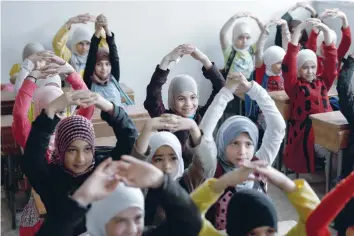  ?? — AFP ?? Schoolchil­dren learn how to protect themselves in case of a bombardmen­t during a war safety awareness class as part of a campaign conducted by the Syrian civil defence, known as The White Helmets, in the rebel-held area of Harasta, on the northeaste­rn...