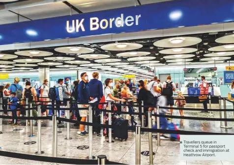  ?? ?? Travellers queue in Terminal 5 for passport check and immigratio­n at Heathrow Airport.