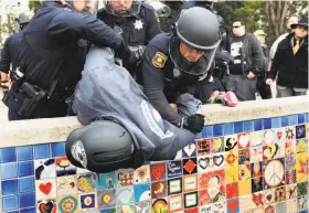  ?? Noah Berger / Special to The Chronicle ?? BERKELEY, MARCH 4: Police officers detain a pro-Trump demonstrat­or during a clash between supporters and opponents of the president. Twenty-three were arrested.