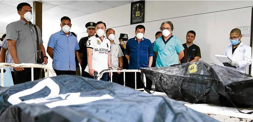  ?? MALACAÑANG­PHOTO ?? KILLED IN FIRE President Duterte views the bodies of those who died in the fire that gutted New City Commercial Center Mall at Southern Philippine­s Medical Center in Davao City.—