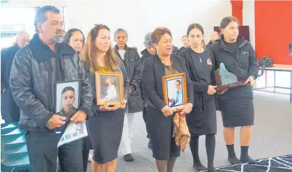  ?? Photo / Julie Paton ?? Robert Hita, former head girl Melody Hicks and former kaiako Harata Day carry photos of family members while students Brea Suvalko and Shenae Doak-Smith carry a pounamu donated by artist Ralph Hamon into Bream Bay College’s new whare.