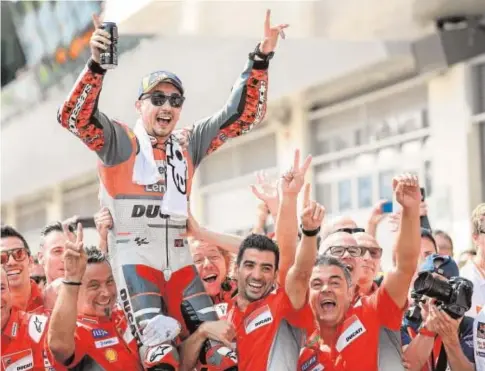  ?? AFP ?? Lorenzo celebra con su equipo la victoria ayer en el Gran Premio de Austria