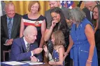  ?? EVAN VUCCI ASSOCIATED PRESS ?? President Joe Biden gives the pen he used to sign a veterans aid bill Wednesday to Brielle Robinson, daughter of Sgt. 1st Class Heath Robinson, who died of cancer two years ago.