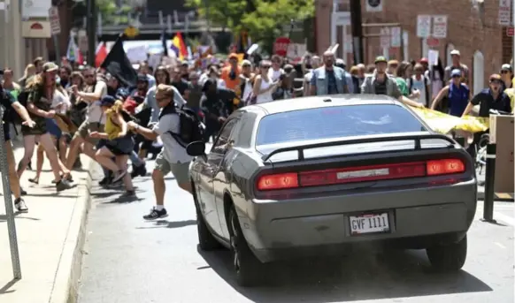  ?? RYAN M. KELLY/THE DAILY PROGRESS VIA THE ASSOCIATED PRESS ?? A car plowed into a group of people protesting a white supremacis­t rally in Charlottes­ville, Va., on Saturday, leaving one person dead and at least 19 injured. The driver was later arrested.