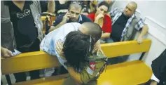  ?? (Baz Ratner/Reuters) ?? ELOR AZARIA, the soldier charged with manslaught­er in the March 24 Hebron shooting, is hugged by his mother during a hearing in the Jaffa Military Court yesterday.