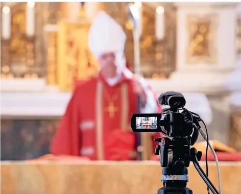  ?? FOTO: DPA ?? Der Erfurter Weihbischo­f Reinhard Hauke bei der Internetüb­ertragung eines Gottesdien­stes am Palmsonnta­g in der liturgisch­en Farbe Rot. An Ostern werden weiße Gewänder getragen.