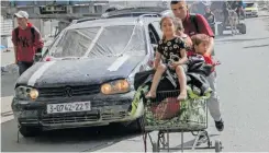  ?? | Reuters ?? A DISPLACED Palestinia­n man, who fled Jabalia after the Israeli military called on residents to evacuate, pushes children in a trolley as they make their way towards Gaza City, amid Israel-Hamas conflict yesterday.