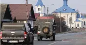  ?? SEAN GALLUP Getty Images ?? Polish military vehicles drive past an Orthodox church in Dubiny, Poland, near the border with Belarus on Thursday.