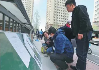  ?? WANG ZHUANGFEI / CHINA DAILY ?? Prospectiv­e tenants check informatio­n about a public rental housing project in Beijing’s Chaoyang district.