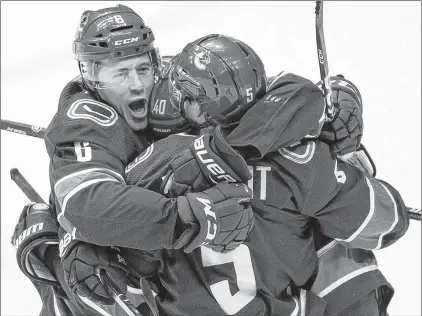  ?? CP PHOTO ?? Vancouver Canucks’ Brock Boeser, from left, Elias Pettersson and Derrick Pouliot celebrate Pouliot’s winning goal against the Colorado Avalanche in overtime Friday night in Vancouver.