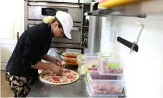  ??  ?? An employee of pizzeria “Pizza Veterano” prepares pizza to be delivered to the frontline.