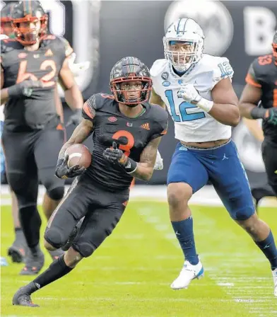  ?? MICHAEL LAUGHLIN/SUN SENTINEL ?? Miami receiver Mike Harley runs ahead of North Carolina’s Tomon Fox last seson at Hard Rock Stadium.