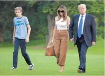  ?? CAROLYN KASTER/ASSOCIATED PRESS ?? President Donald Trump, first lady Melania Trump, and their son and Barron, walk from Marine One to the White House last week.