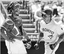  ?? JAYNE KAMIN-ONCEA GETTY IMAGES ?? Martin Maldonado, left, of the Los Angeles Angels looks on as Curtis Granderson of the Toronto Blue Jays crosses the plate after hitting a solo home run in the sixth inning.