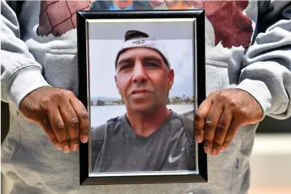  ?? Photograph: Bianca de Marchi/AAP ?? Family and friends hold a photo of Stanley Russell at the inquest into his death, which has heard from one of the police officers who shot at him.