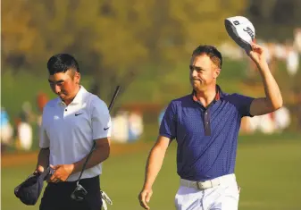  ?? Mike Ehrmann / Getty Images ?? Next to Doug Ghim, Justin Thomas acknowledg­es the fans on his way to the 18th green in the final round of the Players Championsh­ip. He parred the hole to win the event by one shot.