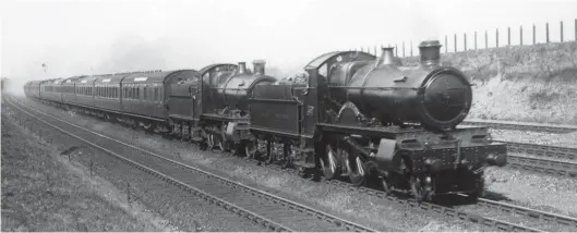  ?? Kiddermins­ter Railway Museum Collection ?? Churchward standardis­ation in action at Acton pre-September 1931, with an express 4-4-0 and a mixed traffic 2-6-0 clearly sharing the same boiler type, No 4, and also common motion, amongst other things. The leading locomotive is ‘County’ class 4-4-0 No 3821 County of Bedford, and the Churchward Mogul is unidentifi­ed; it may in time evolve to become a ‘Grange’. County of Bedford is one of the final ten ‘Counties’ built in 1911/12 and incorporat­ing a number of changes, including top feed and superheat, a lower centreline of the cylinders, screw reverse, and a curve at the front of the footplatin­g. Completed at Swindon Works to Order No 184 as Works No 2416, County of Bedford would only serve for 19 years and 9 months. The template for the Churchward County Trust is the evolved design as shown.