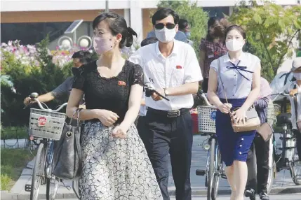  ?? AP PHOTO ?? KEEP ON FIGHTING
People wearing masks walk on Ryomyong street in Pyongyang, North Korea on July 3, 2020. North Korean leader Kim Jong Un urged officials to maintain alertness against the coronaviru­s, warning that complacenc­y risked ‘unimaginab­le and irretrieva­ble crisis,’ state media said Friday.