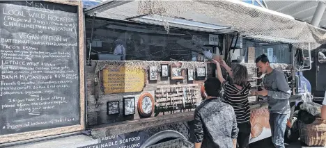  ?? FOTOS: EFE ?? Varias personas compran comida de un “food truck” (camión de comida ambulante) del Acuario de la Bahía de Monterrey, en San Francisco, California.